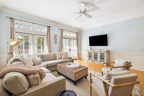 Sink into plush sofas in your bright living room, where natural light streams through French doors and a ceiling fan keeps you comfortable.