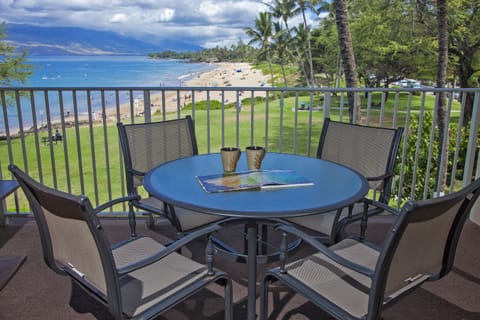 Sip your morning coffee on your private balcony overlooking pristine beach, turquoise waters, swaying palms, and distant mountains—your tropical paradise awaits.