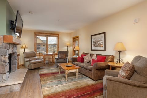 Sink into plush seating by your crackling fireplace, where warm lighting and mountain views create your perfect retreat.