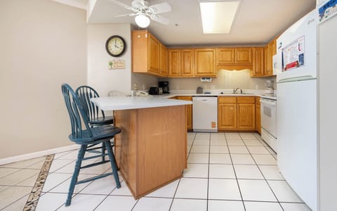 Prepare meals in the spacious kitchen featuring ample counter space, wooden cabinets, and seating at the breakfast bar