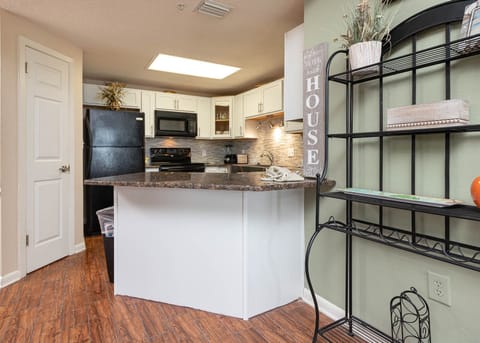 Prepare meals in this stylish kitchen featuring black appliances and a welcoming atmosphere for gathering