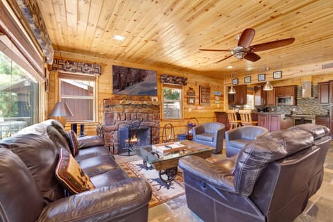 Cozy mountain living room with a stone fireplace, comfy seating, and smart TV—perfect for relaxing evenings, movie nights, and warm cabin vibes after outdoor adventures.