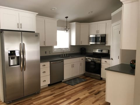 New Kitchen with white cabinets, gray quartz countertops, Hickory flooring