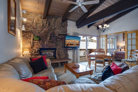 Unwind by your crackling stone fireplace in this cozy mountain retreat, where rustic beams and plush seating create the perfect spot for relaxation.