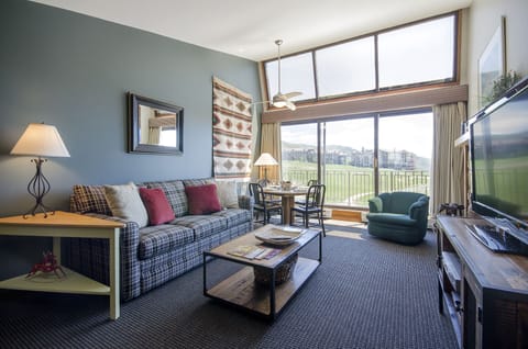Relax in your thoughtfully designed living space with cozy plaid seating, panoramic windows, and a perfect dining nook for morning coffee.