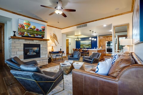 Relax in your spacious living room featuring a cozy fireplace, comfortable leather seating, and modern amenities for perfect mountain getaway moments.