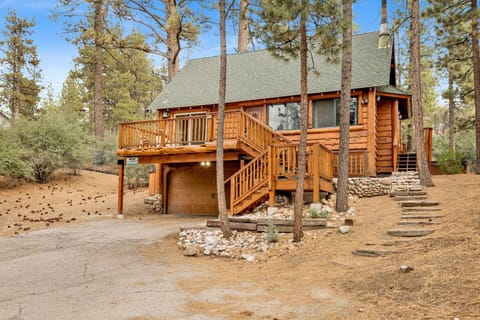Showcasing the full architectural charm of the cabin, this view highlights the expansive deck and integrated garage.