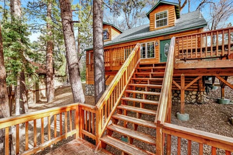Welcoming cabin entry surrounded by towering pine trees, offering fresh mountain air and a peaceful forest setting—the perfect first impression for your Big Bear Lake getaway.
