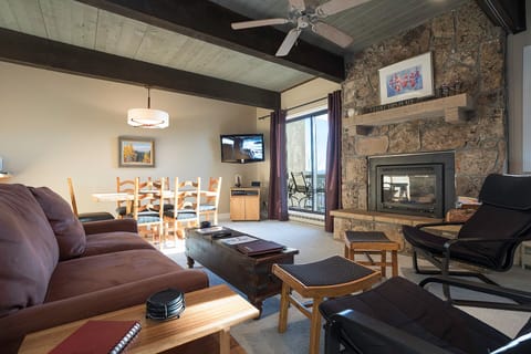 Cozy up by your stone fireplace with exposed beams overhead, perfect for mountain evenings after adventure-filled days.