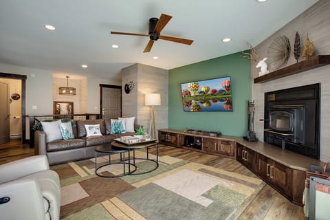 Unwind in your stylish living room featuring leather seating, a cozy fireplace, and modern entertainment center for perfect relaxation.