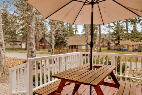 Private cabin deck with BBQ grill and picnic table, perfect for outdoor dining, grilling, and relaxing among tall pines—ideal for cozy mountain stays and memorable Airbnb getaways.