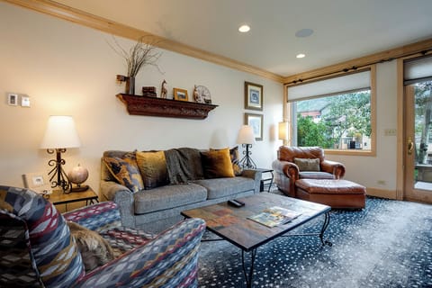 Sink into plush seating by the window where natural light streams across warm wood accents and thoughtful décor.