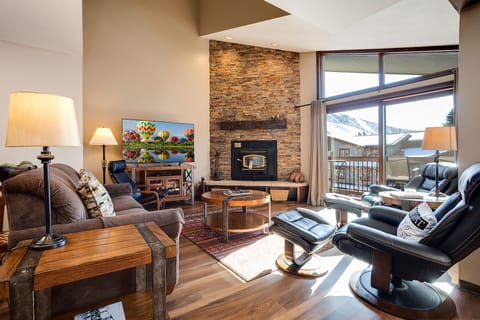 Cozy up by your stone fireplace while taking in stunning mountain views from these plush leather chairs and comfortable sofas.