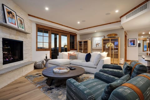 Sink into plush seating by your crackling fireplace, where warm wood tones and soft lighting create the perfect evening retreat.