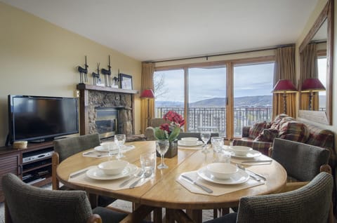 Your cozy mountain retreat features a dining table set for memorable meals and a fireplace for evening relaxation.