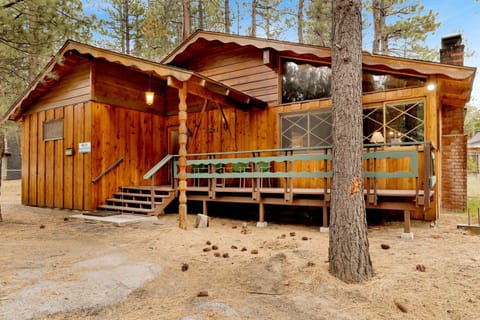 Welcoming cabin entry surrounded by towering pine trees, offering fresh mountain air and a peaceful forest setting—the perfect first impression for your Big Bear Lake getaway.