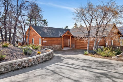 Welcoming cabin entry surrounded by towering pine trees, offering fresh mountain air and a peaceful forest setting—the perfect first impression for your Big Bear Lake getaway.