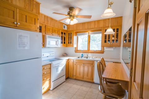 Kitchen fridge, oven, double sink, dishwasher, bar, & pantry/appliance closet.