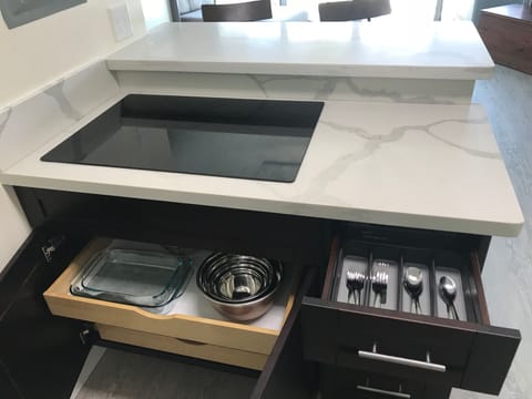 Breakfast bar cooktop with all the proper cooking utensils.