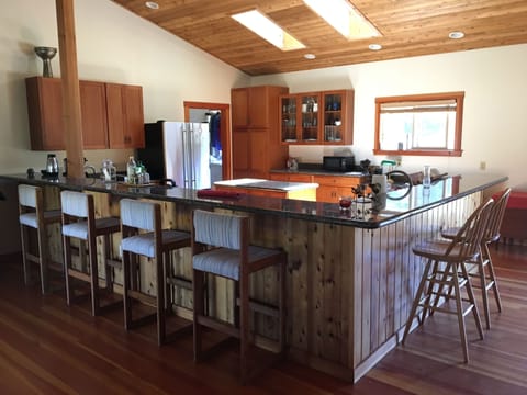 Spacious kitchen counters with stools, center island, skylights.