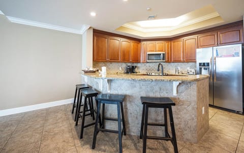 The kitchen features wooden cabinetry, granite countertops, stainless appliances, a Keurig and a coffee maker for morning cup