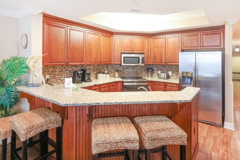 This kitchen features wood cabinetry, granite countertops, modern appliances, and a convenient Keurig coffee maker