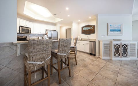 The kitchen features stainless appliances, granite countertops, and a stylish bar, perfect for casual dining and entertaining