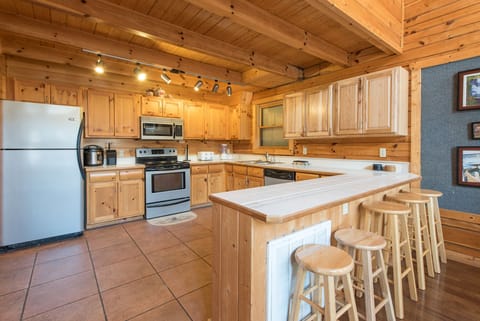 Fully Equipped Kitchen with Stainless Steel Appliances and Breakfast Bar Seating for Four
