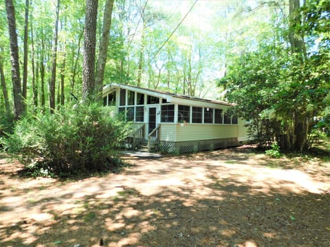 19 Addy Road - Charming Middlesex Beach Cottage - Nestled among mature trees in the private community of Middlesex Beach, this classic coastal retreat offers the perfect blend of seclusion and beachside convenience. The expansive screened-in porch serves as a primary feature for enjoying the tranquil, wooded surroundings.