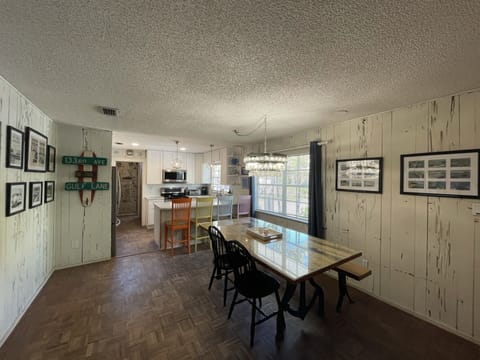 Dining area w\ original cypress walls, 100 year old table, breakfast bar & cool capiz shell light.