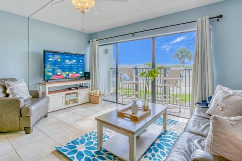 Bright and stylish living room with a large TV and balcony access