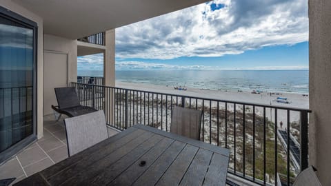 Relax at the outdoor table while enjoying the stunning views of the water and beach from your balcony