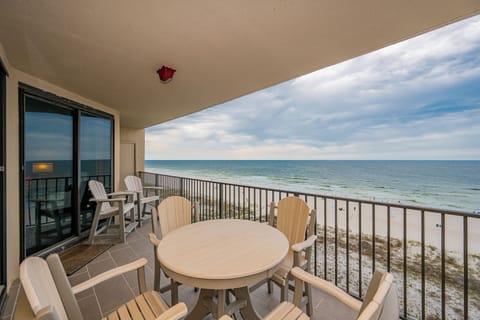 Relax at the patio table with chairs, enjoying the view of the water and beach from your spacious balcony