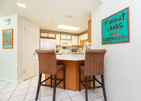 Enjoy casual meals at the breakfast bar, featuring woven seating and a welcoming kitchen with vibrant decor