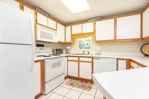 Cook and enjoy meals in this functional kitchen featuring ample counter space and cheerful decor