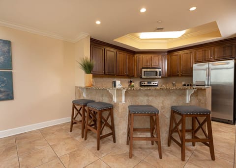 The kitchen features rich wooden cabinetry, granite countertops, and stainless appliances, perfect for culinary adventures