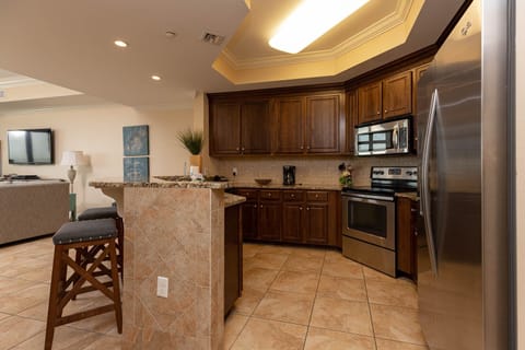 This kitchen features stainless appliances, granite countertops, and a bar area, perfect for casual dining and entertaining
