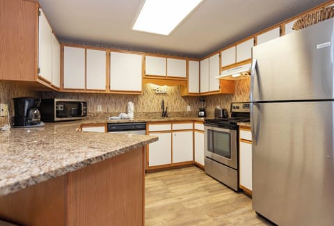 Cook and enjoy meals in this functional kitchen featuring sleek appliances and ample counter space for preparation