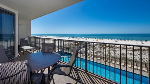 Savor meals or relax on the balcony with comfortable seating and views of the beach and inviting pool below