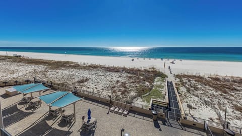 Relax on the spacious patio with shaded seating, just steps from the inviting shoreline and sparkling water