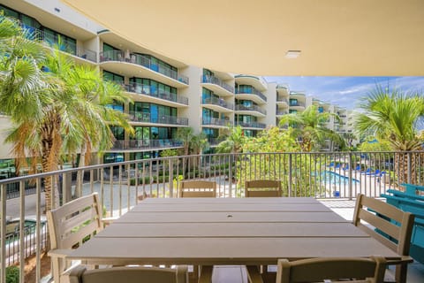 Savor the coastal breeze on your inviting balcony, surrounded by lush greenery and poolside tranquility