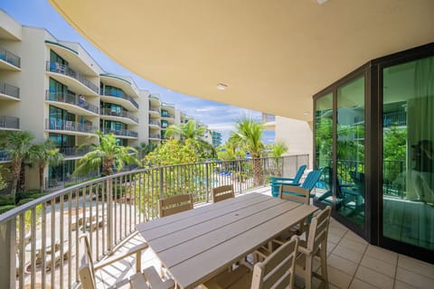 Relax on the spacious balcony, soaking in the tranquil ambiance with lush greenery and poolside views