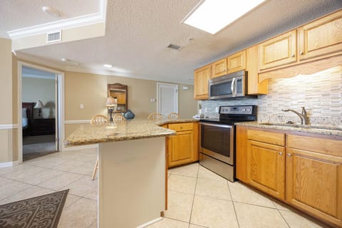 Prepare meals in the spacious kitchen featuring granite countertops, stainless appliances, and a breakfast bar