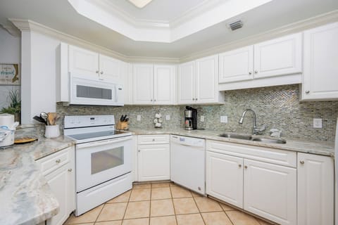Whip up your favorite meals in this inviting kitchen, featuring ample counter space and a stylish backsplash