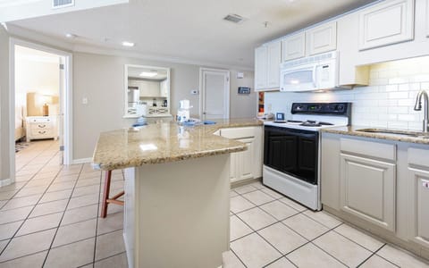 Cook and gather in this spacious kitchen with a large counter, sleek appliances, and a welcoming layout for shared meals