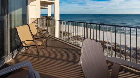 Relax on the balcony in comfortable seating, enjoying expansive views of the water and beach below