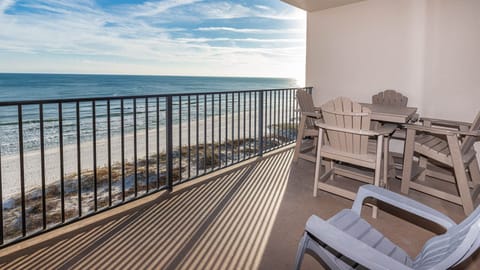 Savor the view from the balcony with comfortable seating, perfect for relaxing while enjoying the coastal breeze