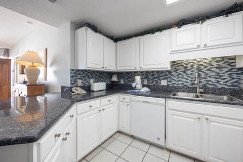 Prepare meals in this tylish kitchen, featuring sleek countertops and ample storage for your culinary needs