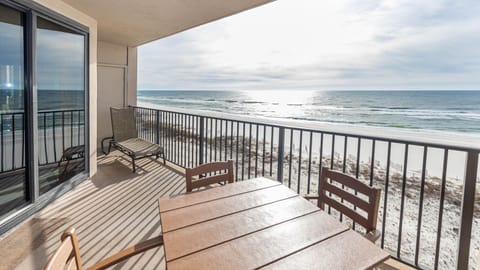 Savor the fresh air from your balcony, featuring a table and chairs with views of the tranquil waters and shoreline
