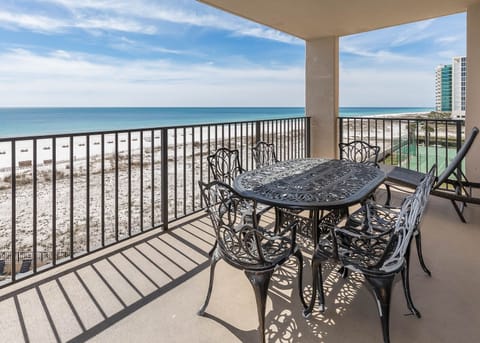 Dine al fresco at the elegant table, enjoying refreshing breezes and stunning beach views of the tranquil waters